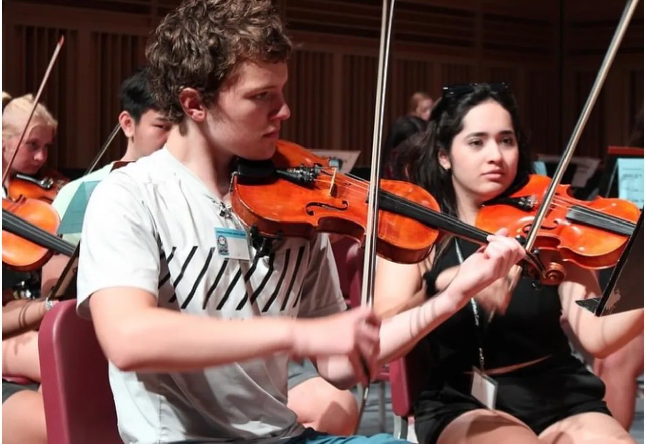 Estudiantes de violín ensayando en la orquesta juvenil de FARECOH